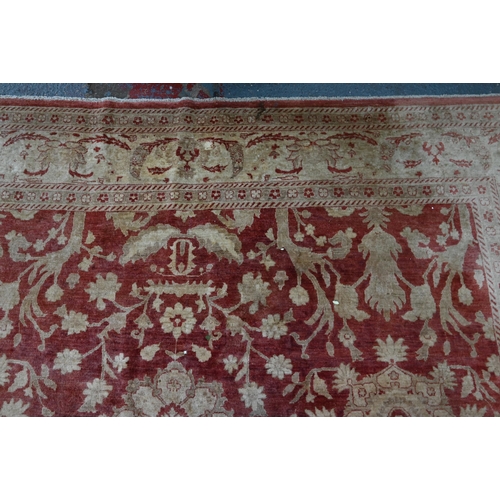 608 - A contemporary Agra carpet, the pale coral ground with repeating floral designs in pale yellow-gold,... 