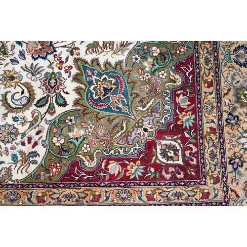 609 - An Indo-Persian Quom carpet, the camel ground centred by a floral medallion, the field woven with bi... 