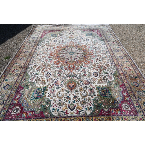 609 - An Indo-Persian Quom carpet, the camel ground centred by a floral medallion, the field woven with bi... 