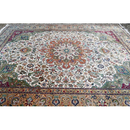 609 - An Indo-Persian Quom carpet, the camel ground centred by a floral medallion, the field woven with bi... 