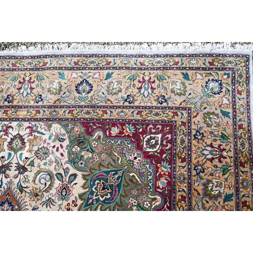 609 - An Indo-Persian Quom carpet, the camel ground centred by a floral medallion, the field woven with bi... 