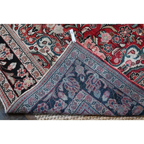 613 - An old Persian Mahal small carpet, the centre floral medallion design on red ground, 306 cm x 214 cm