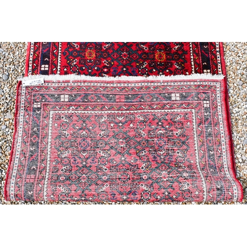 622 - A Persian Hamadan hall runner, the repeat design of stylised flowers on red ground, 515 cm x 85 cm