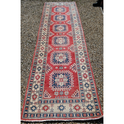 623 - A contemporary Agra runner, the pale coral ground with geometric floral design, 328 cm x 91 cm