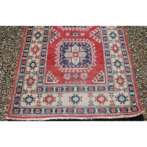 623 - A contemporary Agra runner, the pale coral ground with geometric floral design, 328 cm x 91 cm