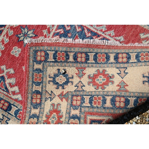 623 - A contemporary Agra runner, the pale coral ground with geometric floral design, 328 cm x 91 cm