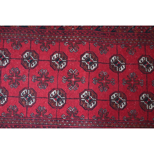 626 - An old Turkoman red ground rug, with three rows of geometric guls, 160 cm x 105 cm to/with a Pakista... 