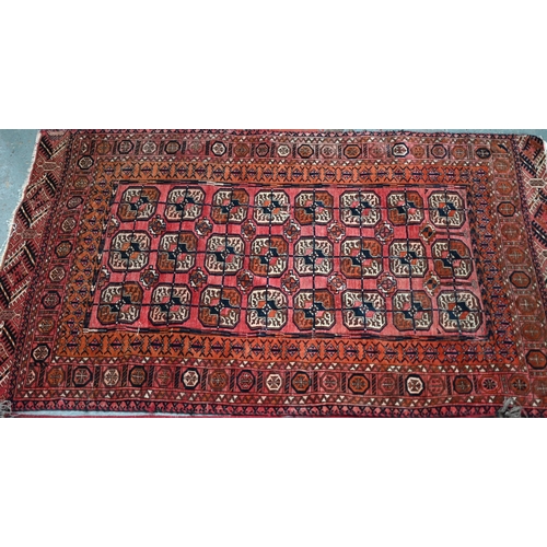 626 - An old Turkoman red ground rug, with three rows of geometric guls, 160 cm x 105 cm to/with a Pakista... 