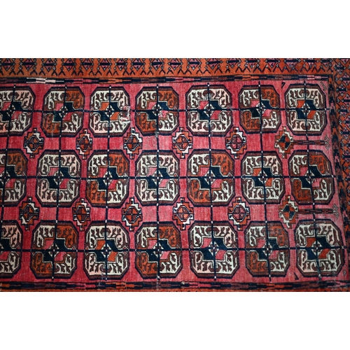 626 - An old Turkoman red ground rug, with three rows of geometric guls, 160 cm x 105 cm to/with a Pakista... 