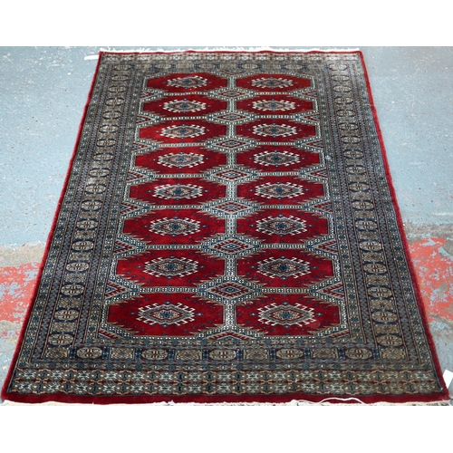 629 - A Persian Turkoman design red ground rug with geometric pole design, 200 cm x 120 cm