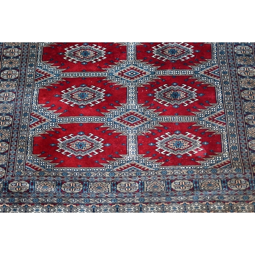 629 - A Persian Turkoman design red ground rug with geometric pole design, 200 cm x 120 cm