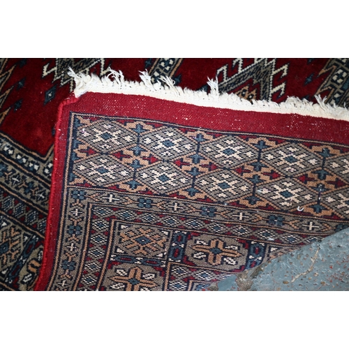 629 - A Persian Turkoman design red ground rug with geometric pole design, 200 cm x 120 cm