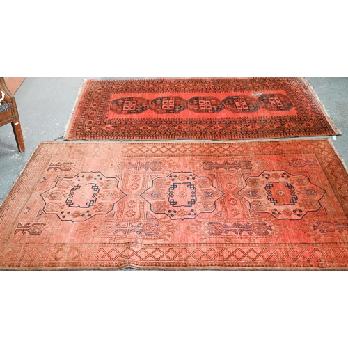 634 - An old Afghan pale red ground lozenge pole design rug, 220 cm x 133 cm, even wear, minor loss to end... 