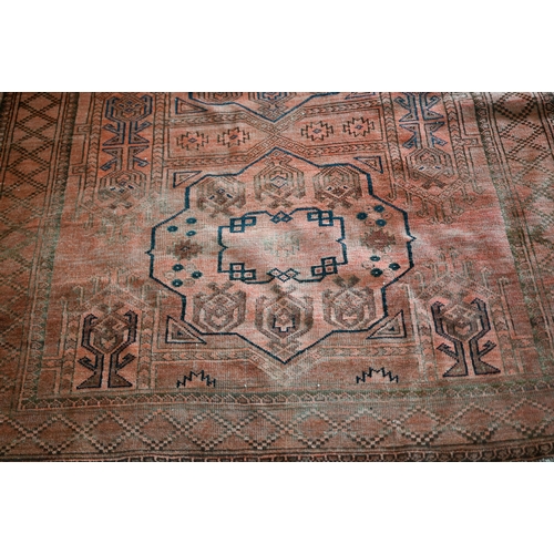 634 - An old Afghan pale red ground lozenge pole design rug, 220 cm x 133 cm, even wear, minor loss to end... 