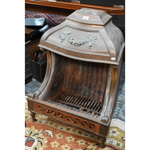 653 - An old cast iron and brass/copper mounted dog-grate, in the style of the Nautilus Stove Co., on rear... 