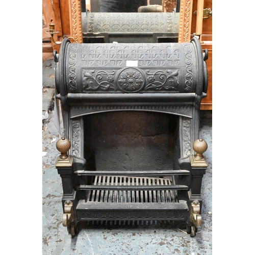 654 - A late Victorian cast iron 'Nautilus' dog-grate fireplace, with brass finials and front mounts, desi... 