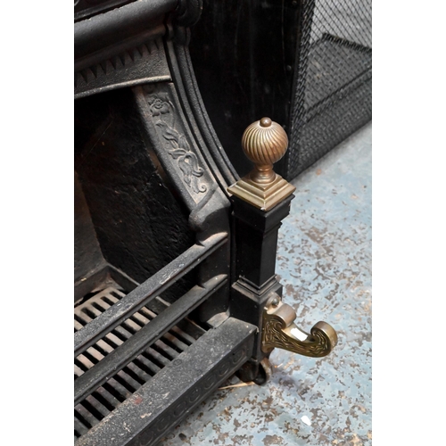 654 - A late Victorian cast iron 'Nautilus' dog-grate fireplace, with brass finials and front mounts, desi... 