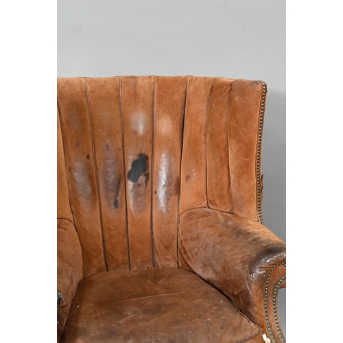 660 - A William IV style porters wing armchair, in battered studded suede and raised on square section fro... 