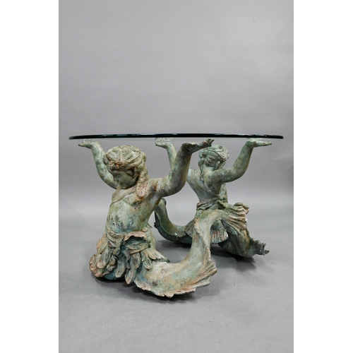 662 - A heavily verdigris patinated bronze coffee table, with circular glass top supported by a pair of li... 