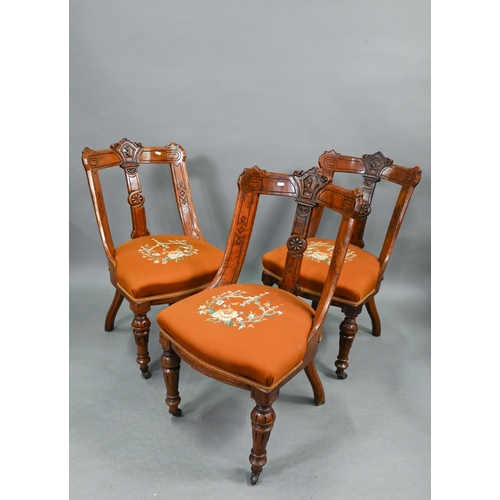 A set of twelve Victorian oak and pollard oak dining chairs, with relief moulded armorial centred back rails for the Withers family, over a vertical shaped and moulded splat, overstuffed embroidered seats and turned and moulded front legs to casters, comprising a pair of carvers and ten side chairs (12)