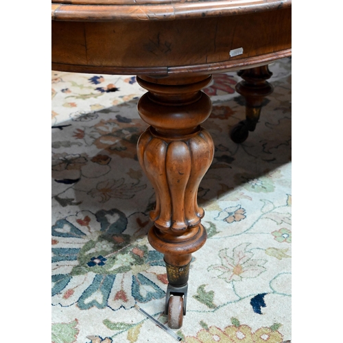 672 - A large Victorian oak extending dining table, the rounded ends united by two wide occasional leaves ... 