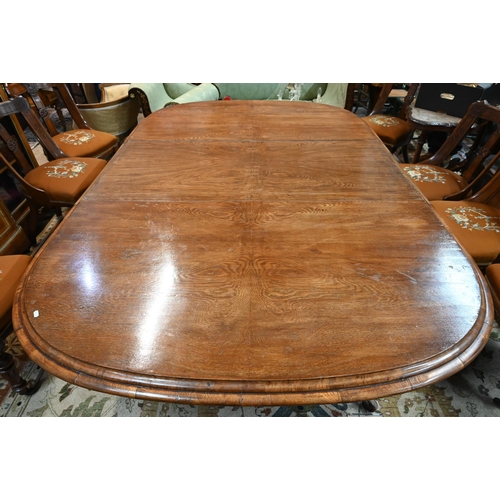 672 - A large Victorian oak extending dining table, the rounded ends united by two wide occasional leaves ... 