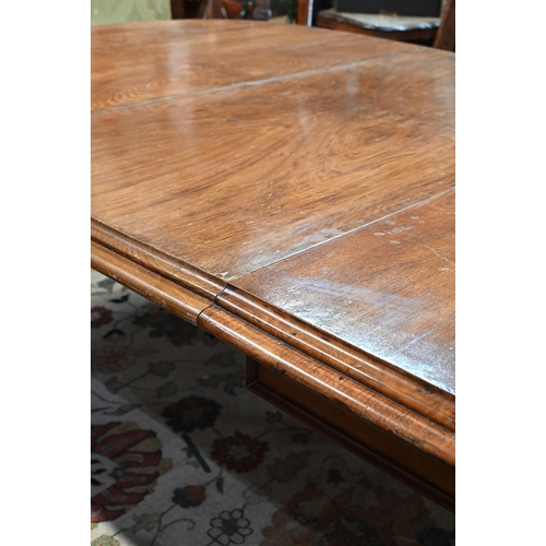 672 - A large Victorian oak extending dining table, the rounded ends united by two wide occasional leaves ... 