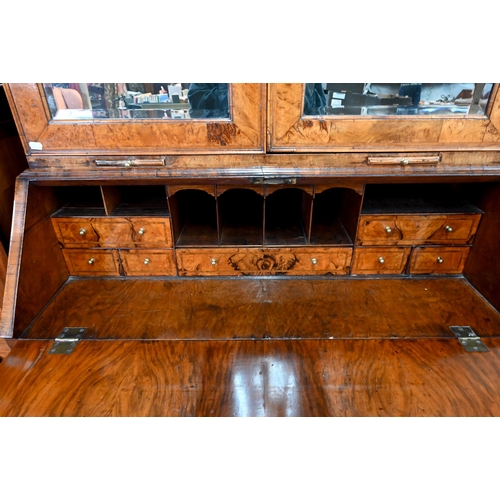 684 - An 18th century walnut bureau cabinet, the shaped cornice over two bevel edged mirror panelled doors... 