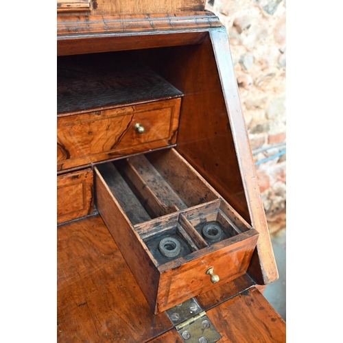 684 - An 18th century walnut bureau cabinet, the shaped cornice over two bevel edged mirror panelled doors... 