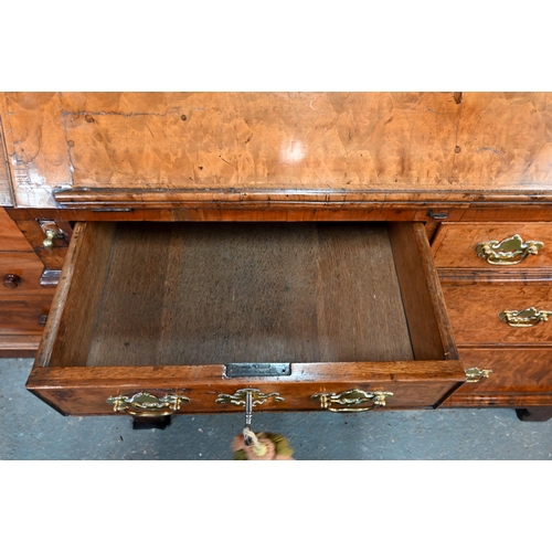 684 - An 18th century walnut bureau cabinet, the shaped cornice over two bevel edged mirror panelled doors... 