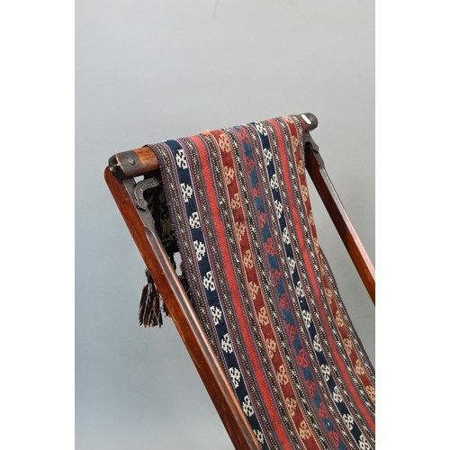 694 - An Afghan folding campaign chair, teak with steel mounts and a single spring action, fitted with a k... 