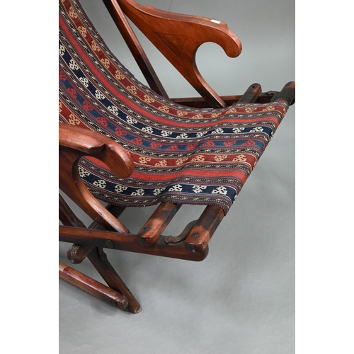 694 - An Afghan folding campaign chair, teak with steel mounts and a single spring action, fitted with a k... 