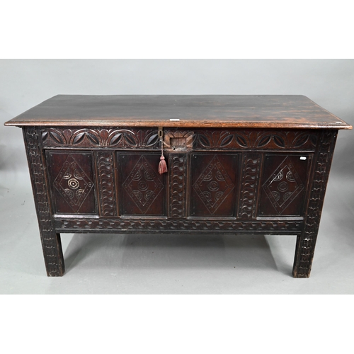 695 - A 17th century oak coffer, the wide two plank top over a lunette carved frieze and four diamond inci... 