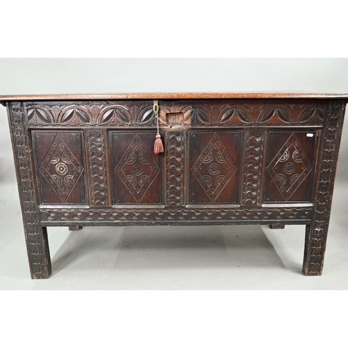 695 - A 17th century oak coffer, the wide two plank top over a lunette carved frieze and four diamond inci... 