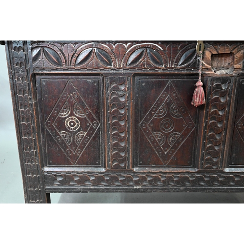 695 - A 17th century oak coffer, the wide two plank top over a lunette carved frieze and four diamond inci... 