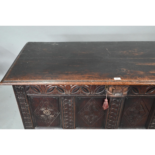 695 - A 17th century oak coffer, the wide two plank top over a lunette carved frieze and four diamond inci... 