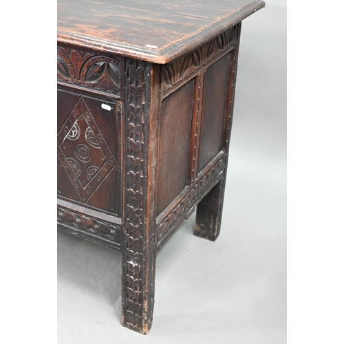 695 - A 17th century oak coffer, the wide two plank top over a lunette carved frieze and four diamond inci... 