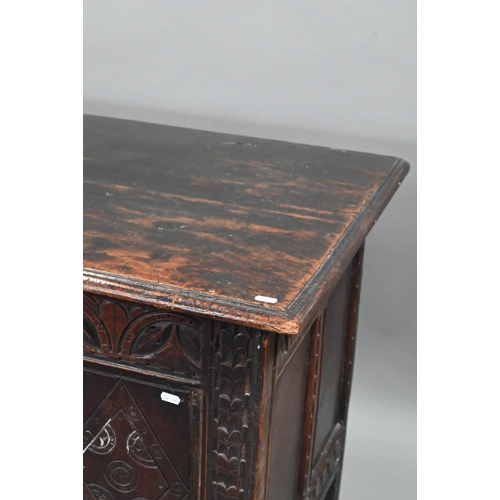 695 - A 17th century oak coffer, the wide two plank top over a lunette carved frieze and four diamond inci... 