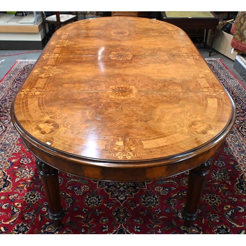 697 - A late 19th century inlaid walnut wind-out dining table, the rounded end top with two wide occasiona... 