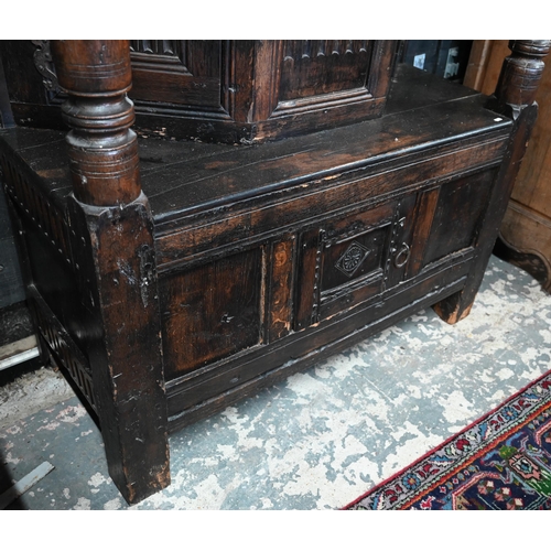 699 - A 17th century oak court cupboard, the recessed canted sided upper cupboard with arcaded moulded pan... 