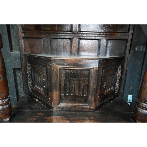 699 - A 17th century oak court cupboard, the recessed canted sided upper cupboard with arcaded moulded pan... 