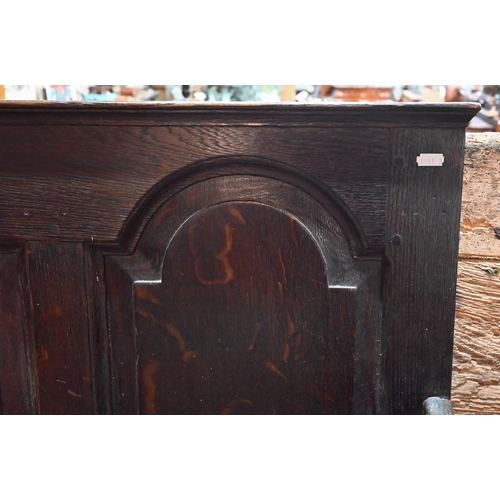 700 - A George III oak settle, the five arched panel back over shaped arms, raised on cabriole front legs,... 