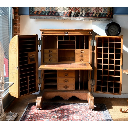 707 - An antique American Wells Fargo 'Wooton' style desk, golden oak, the hinged upper panel over a pair ... 