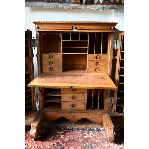 707 - An antique American Wells Fargo 'Wooton' style desk, golden oak, the hinged upper panel over a pair ... 