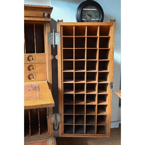 707 - An antique American Wells Fargo 'Wooton' style desk, golden oak, the hinged upper panel over a pair ... 