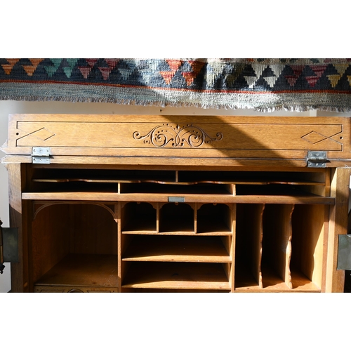 707 - An antique American Wells Fargo 'Wooton' style desk, golden oak, the hinged upper panel over a pair ... 