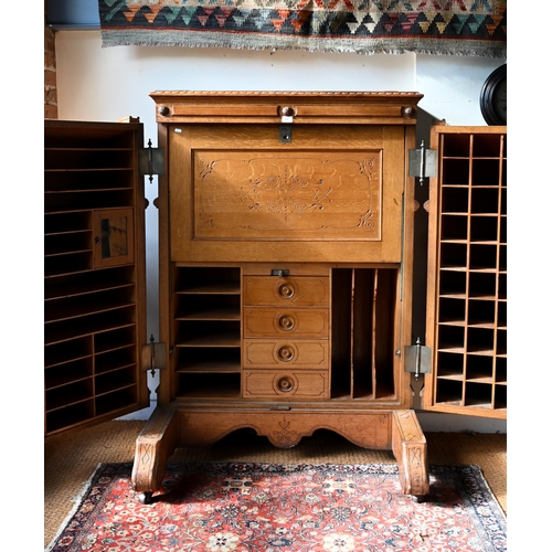 707 - An antique American Wells Fargo 'Wooton' style desk, golden oak, the hinged upper panel over a pair ... 