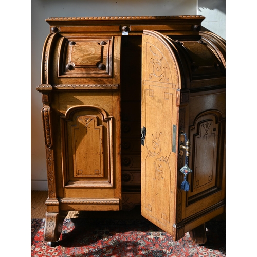 707 - An antique American Wells Fargo 'Wooton' style desk, golden oak, the hinged upper panel over a pair ... 