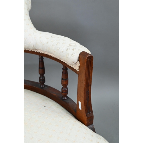 711 - A companion pair of Edwardian walnut bow framed buttoned backed salon chairs, raised on turned front... 