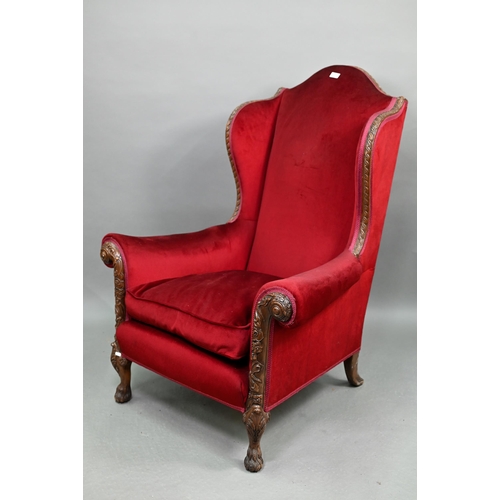 713 - A carved and moulded walnut framed burgundy plush upholstered armchair, with hump back over scroll a... 